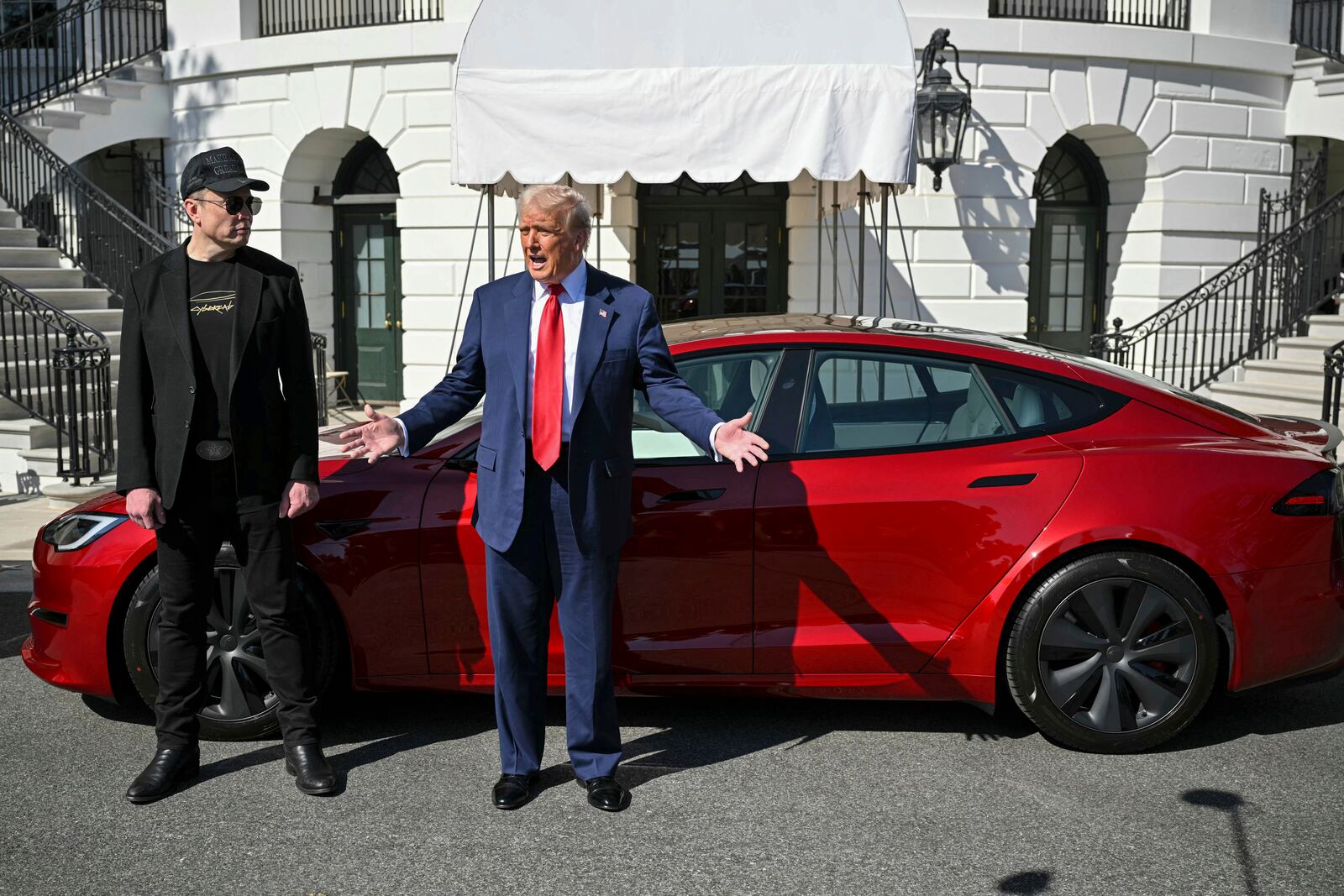 President Donald Trump and Tesla CEO Elon Musk speak to reporters near a red Model S Tesla vehicle on the South Lawn of the White House Tuesday, March 11, 2025, in Washington. (Pool via AP)