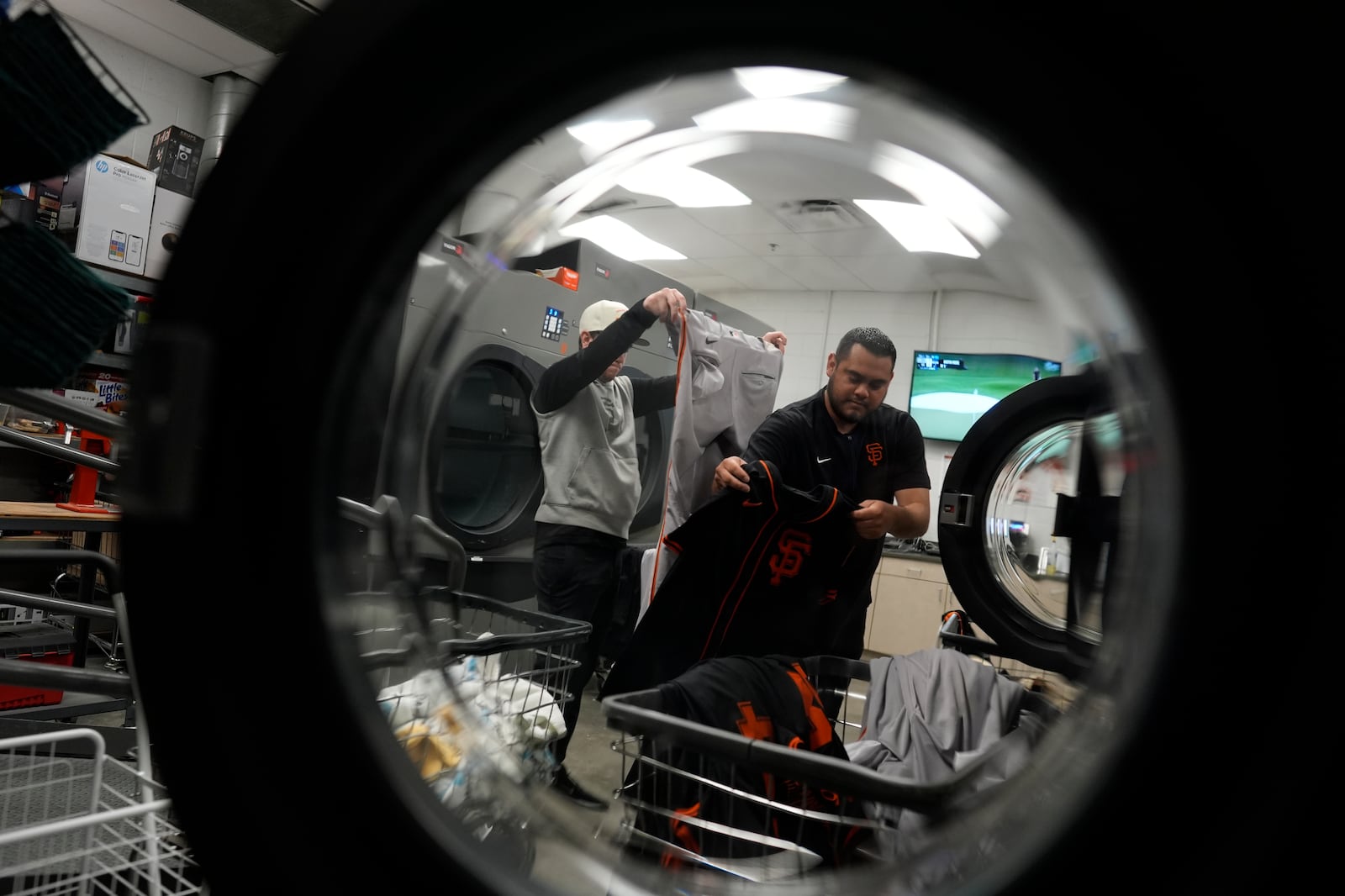 Arturo Maya, right, and Riley Halpin, left, inspect and sort laundry in the San Francisco Giants laundry room during spring training baseball practice at the team's facility, Monday, Feb. 17, 2025, in Scottsdale, Ariz. (AP Photo/Carolyn Kaster)