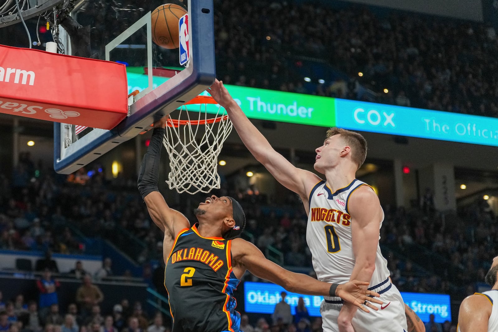 Oklahoma City Thunder guard Shai Gilgeous-Alexander (2) shoots in front of Denver Nuggets guard Christian Braun (0) during the second half of an NBA basketball game, Sunday, March 9, 2025, in Oklahoma City. (AP Photo/Kyle Phillips)