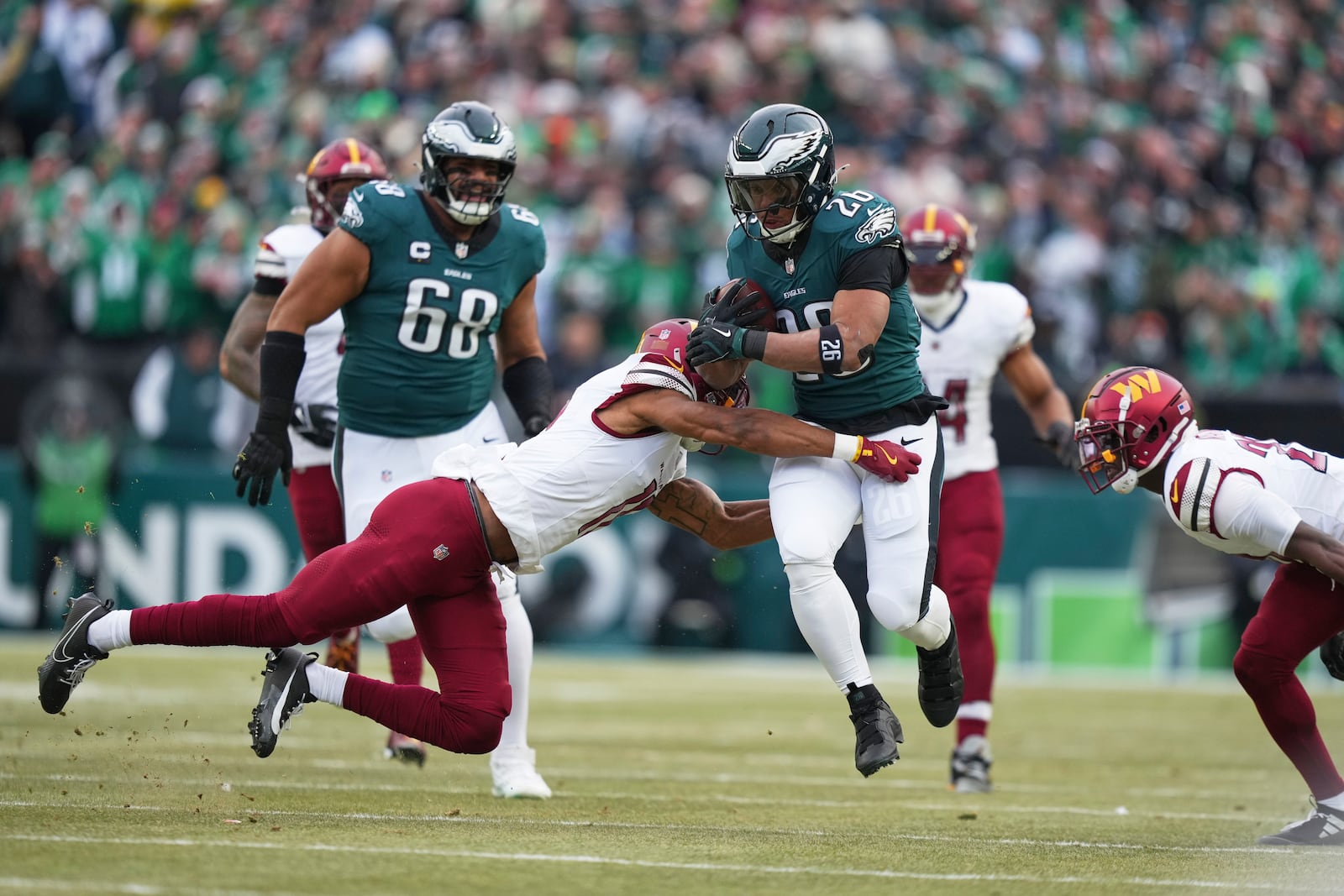 Philadelphia Eagles running back Saquon Barkley (26) breaks away from Washington Commanders safety Jeremy Chinn (11) to score a touchdown during the first half of the NFC Championship NFL football game, Sunday, Jan. 26, 2025, in Philadelphia. (AP Photo/Matt Slocum)