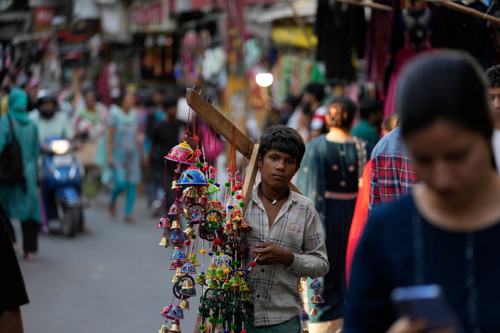 A boy sells artificial decorative flowers of a crowded market on the eve of Diwali, the Hindu festival of lights, in Jammu, India, Wednesday, Oct. 30, 2024.Diwali is one of Hinduism's most important festivals, dedicated to the worship of the goddess of wealth Lakshmi. (AP Photo/Channi Anand)