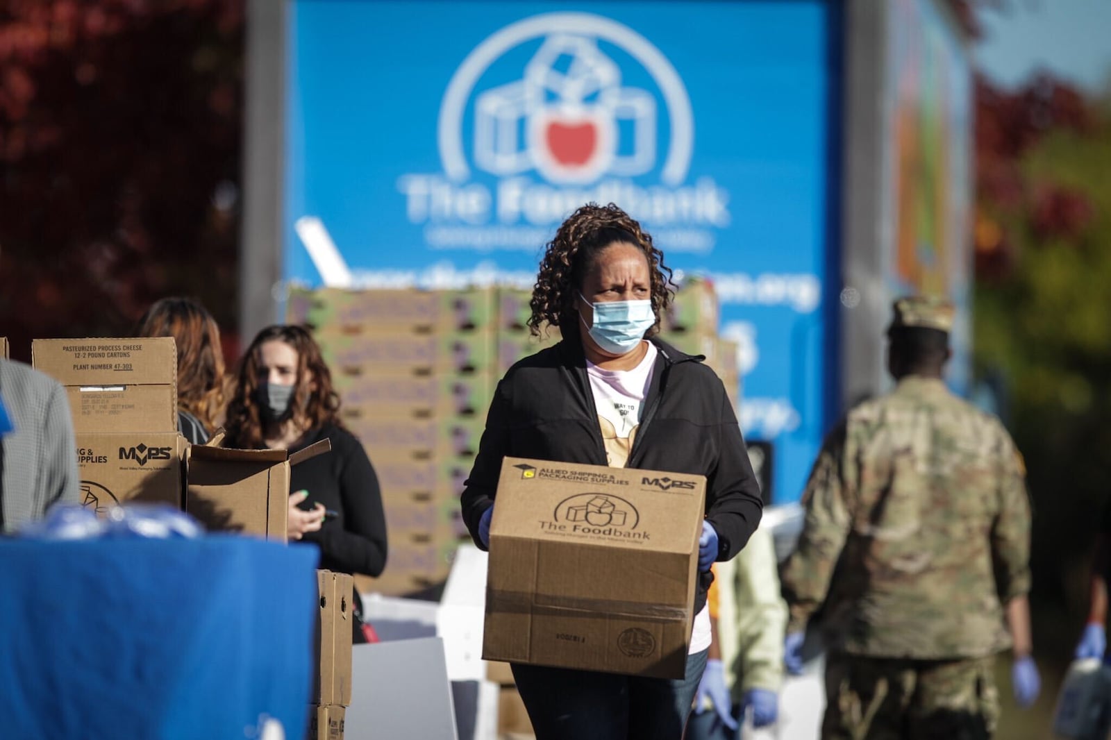 The Foodbank employee Tania Harris distributes food Oct. 8, 2020, behind the Montgomery County courts building in New Lebanon. JIM NOELKER/STAFF