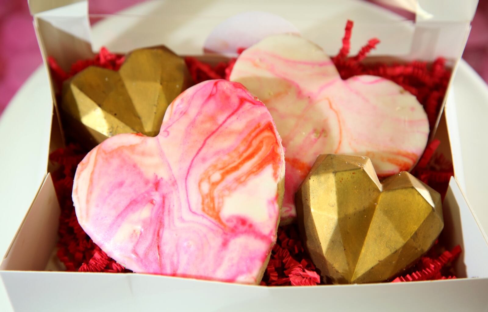 A Little Valentine Mini Box containing two geometric-shaped red velvet cake truffles and two heart shaped shortbread cookies covered in marbled royal icing, vegan and gluten free, is sold by Purely Sweet Bakery, a business that specializes in gluten free, vegan, paleo and keto products, has a variety of baked goods perfect for Valentines Day. LISA POWELL / STAFF