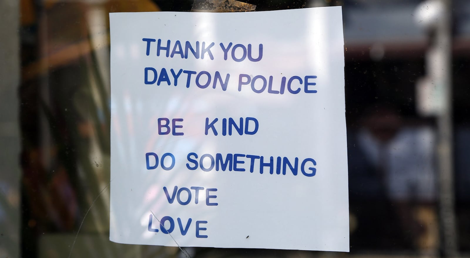 Signs supporting the Dayton Police Department could be found throughout the Oregon District, including this window sign at Feathers, after the mass shooting on Aug. 4, 20219 . TY GREENLEES / STAFF