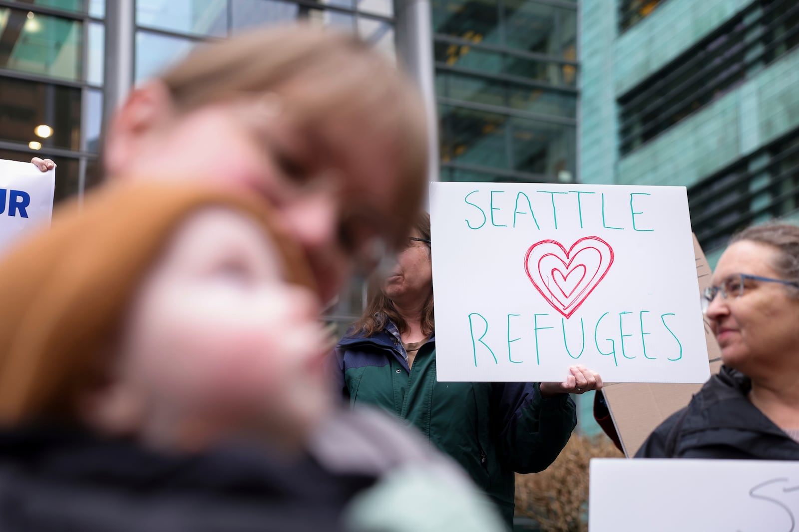 People gather outside the U.S. District Court after a federal judge blocked President Donald Trump's effort to halt the nation's refugee admissions system Tuesday, Feb. 25, 2025, in Seattle. (AP Photo/Ryan Sun)