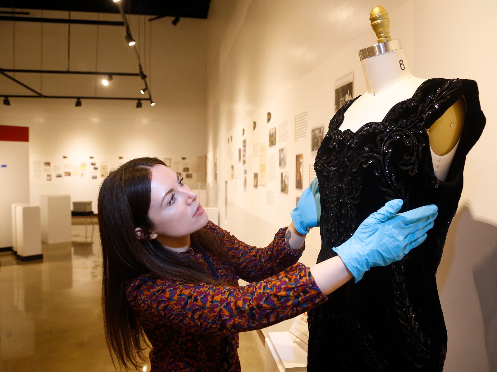 Hadley Drodge, assistant curator at the National Afro-American Museum & Cultural Center in Wilberforce, fits a dress that belonged to civil rights leader Anna Arnold Hedgeman for the new exhibit Color Outside the Lines: Celebrating Thirty Years at NAAMCC. LISA POWELL / STAFF