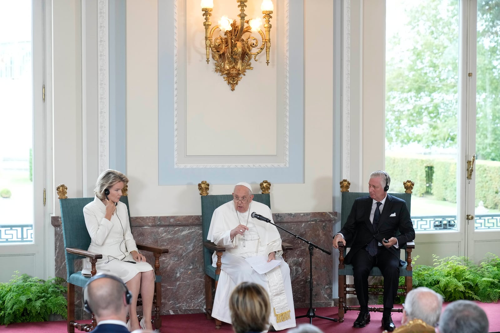 Pope Francis flanked by King Philippe and Queen Mathilde delivers his message during a meeting with the authorities and the civil society in the Grande Galerie of the Castle of Laeken, Brussels, Friday, Sept. 27, 2024. (AP Photo/Andrew Medichini)