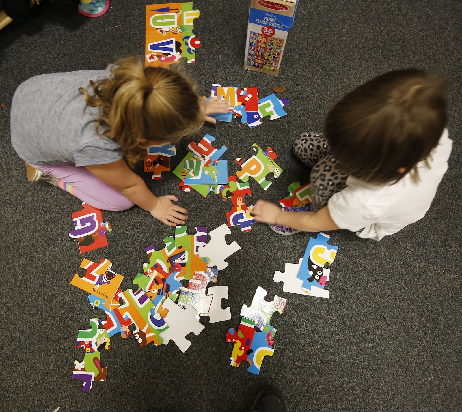 Good Shepherd Academy students Kenzie Dawson, left, and Rickelle Strickland complete a puzzle in a classroom within the Jubilee Community Church in Springboro. TY GREENLEES / STAFF