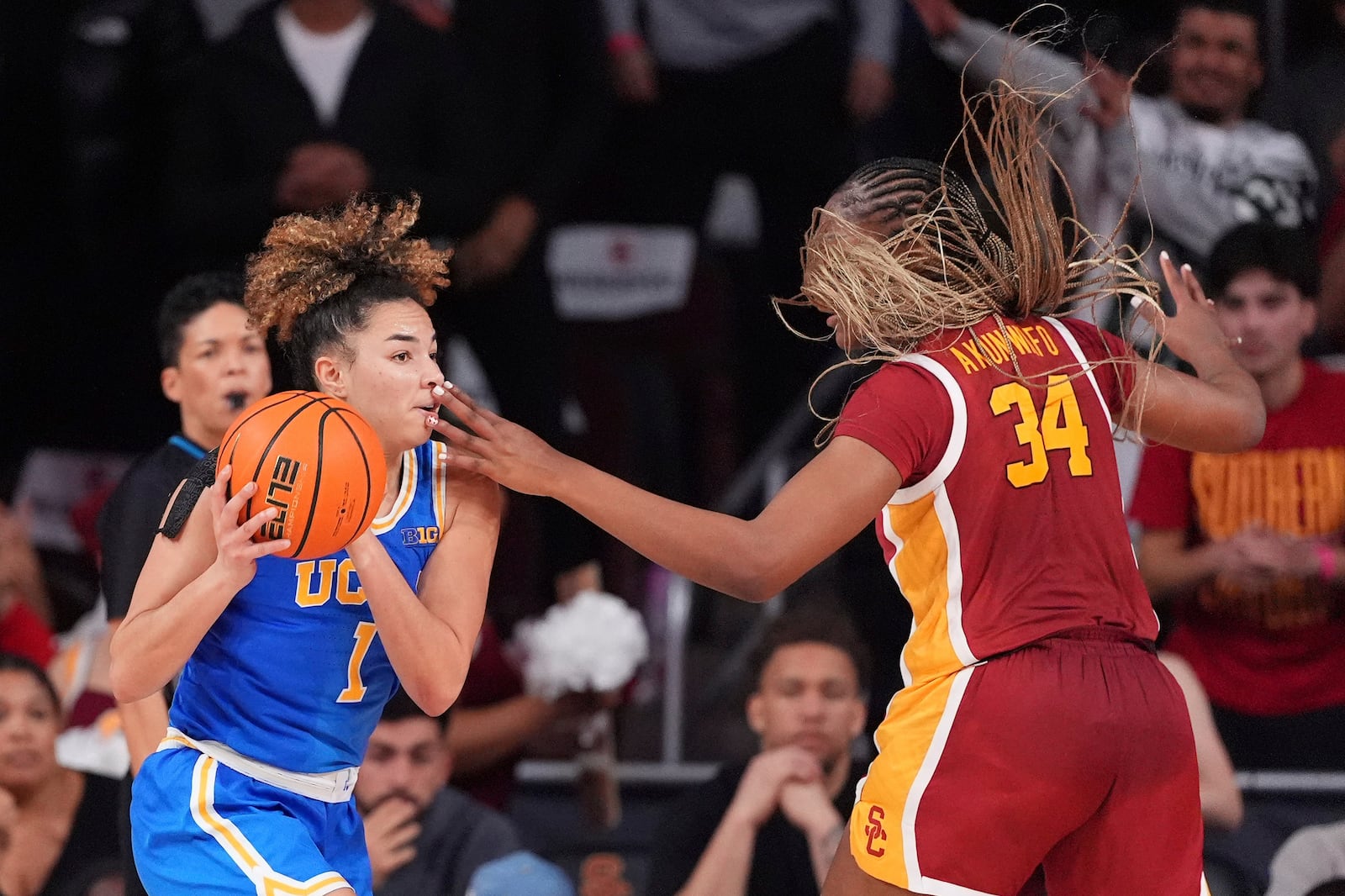 UCLA guard Kiki Rice, left, is hit in the face by Southern California center Clarice Akunwafo while trying to pass during the second half of an NCAA college basketball game, Thursday, Feb. 13, 2025, in Los Angeles. (AP Photo/Mark J. Terrill)