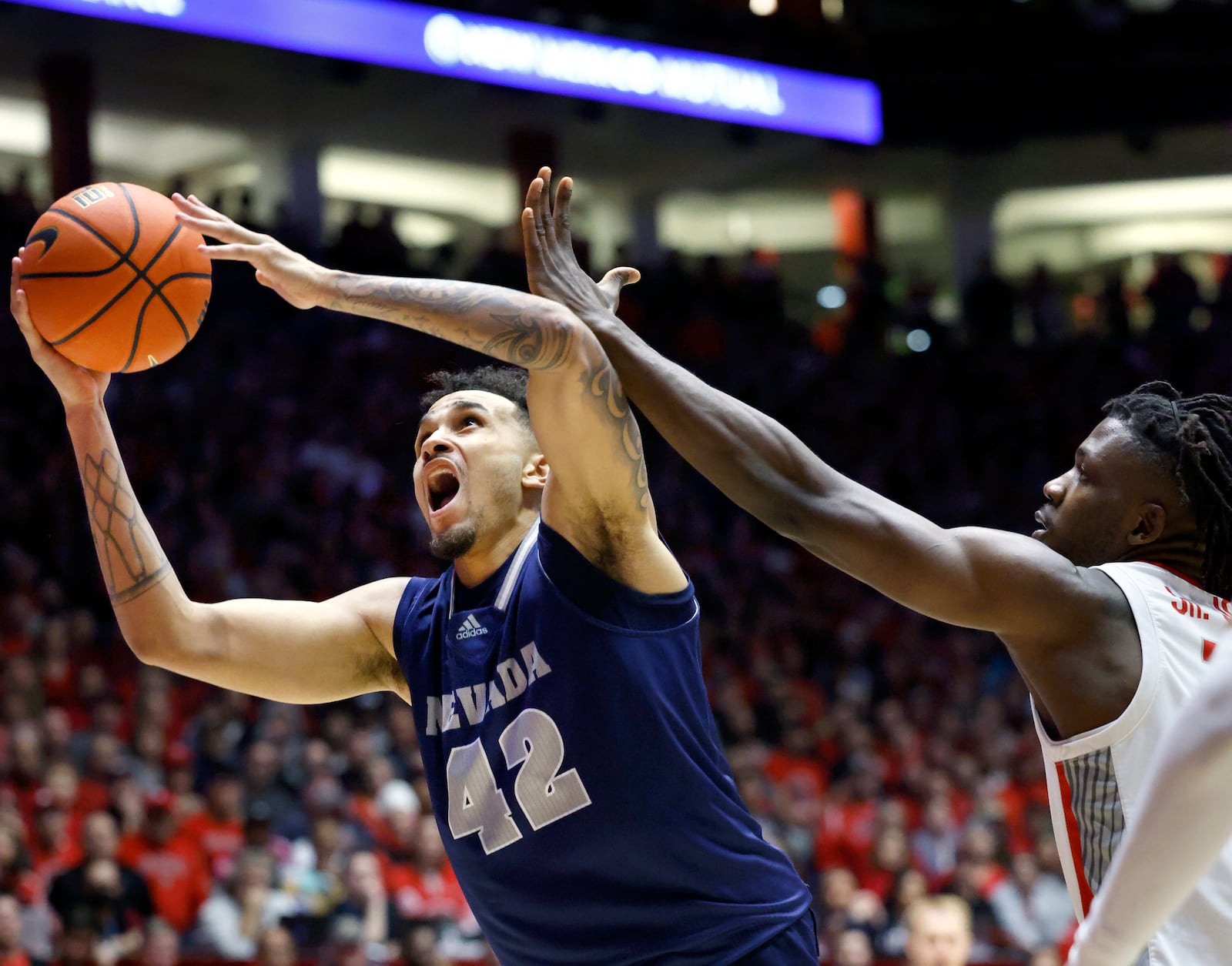 Nevada forward K.J. Hymes grabs an offensive rebound in front of New Mexico center Nelly Junior Joseph during the first half of an NCAA basketball game, Sunday, Jan. 28, 2024, in Albuquerque, N.M. (AP Photo/Eric Draper)