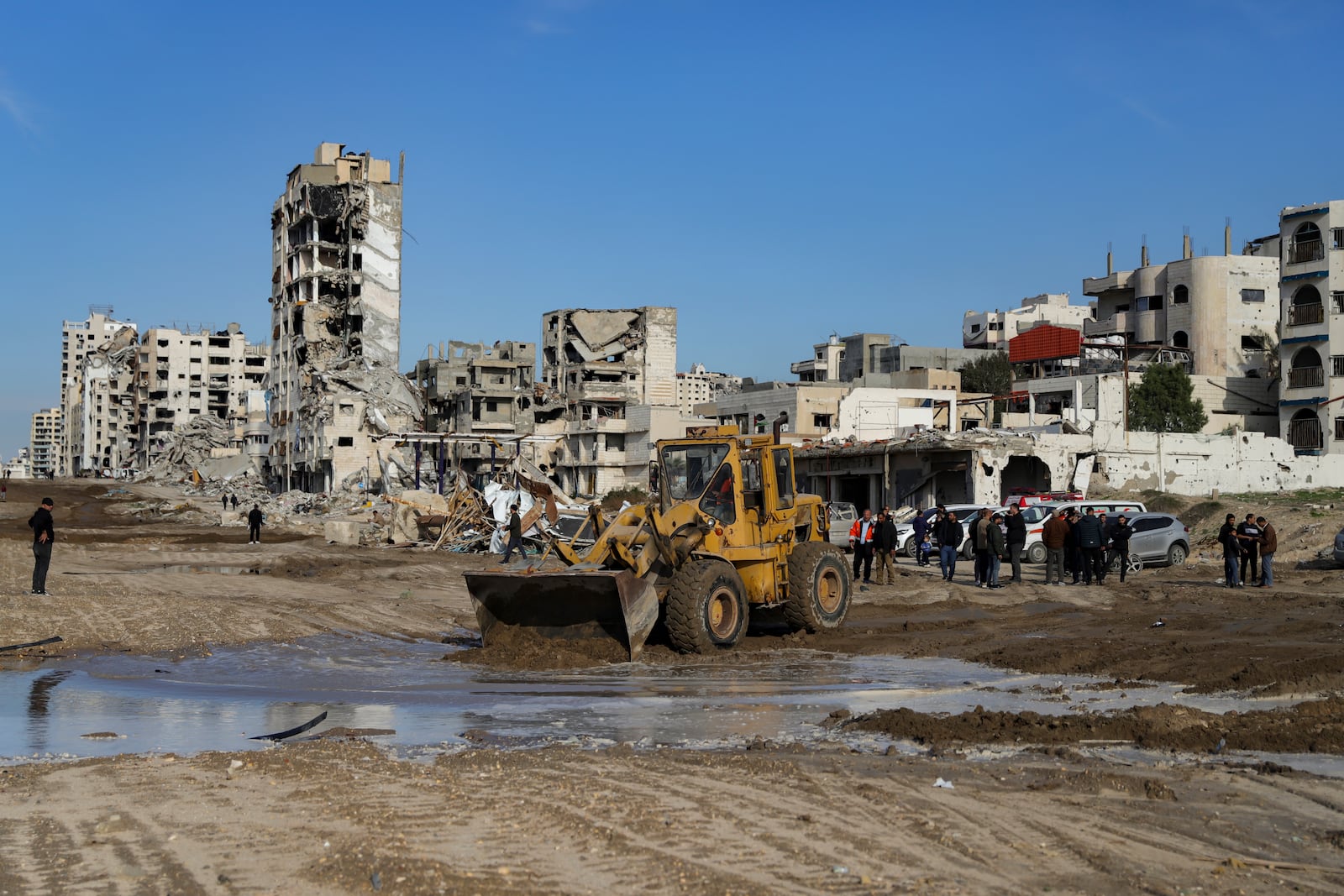 A bulldozer works to open the al Rashid main road for Palestinians who are returning from the southern parts of the Gaza Strip to the north, in Gaza City, Saturday, Jan. 25, 2025, days after the ceasefire deal between Israel and Hamas came into effect. (AP Photo/Abed Hajjar)