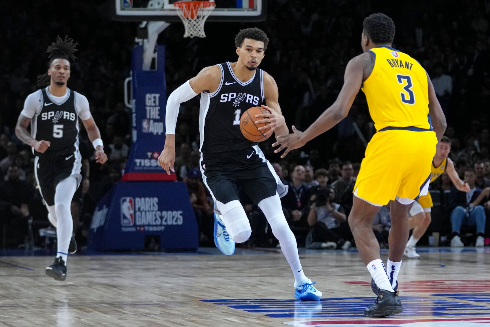 San Antonio Spurs center Victor Wembanyama (1) brings the ball up court under pressure from Indiana Pacers center Thomas Bryant (3) during the second half of a Paris Games 2025 NBA basketball game in Paris, Saturday, Jan. 25, 2025. (AP Photo/Thibault Camus)