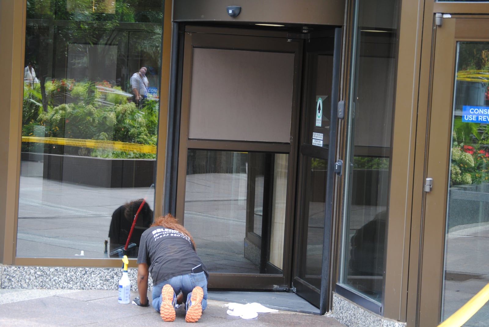 A worker was cleaning and repairing a revolving door at the Fifth Third Center in downtown Cincinnati on Friday, Sept. 7, 2018. On Thursday, a man killed three people and injured two others in a shooting incident at the building. ERIC SCHWARTZBERG / STAFF