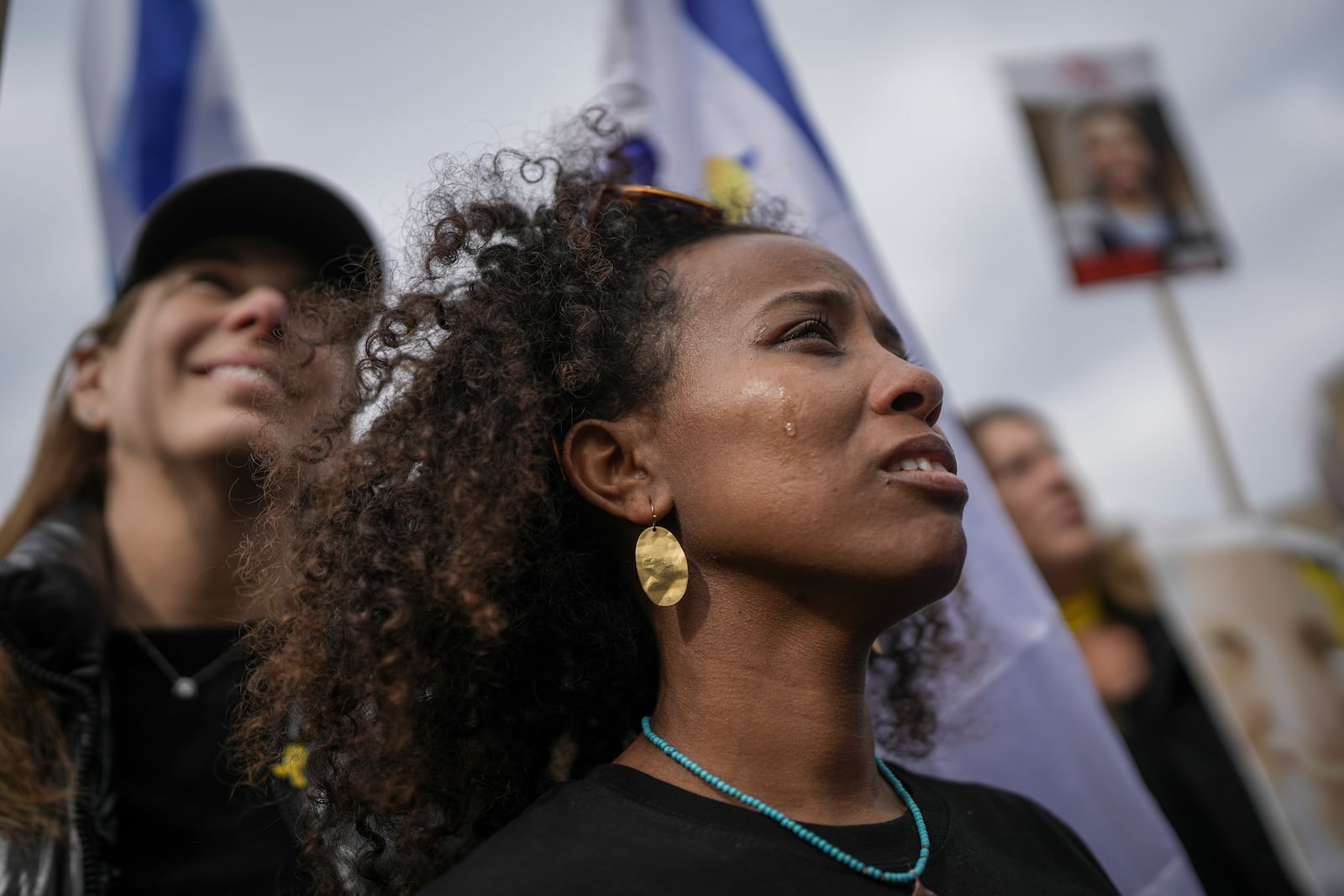 A woman reacts as the first two of six hostages to be released in Gaza by Palestinian militants are handed over to the Red Cross while they watch a live broadcast in 'Hostages Square' in Tel Aviv, Israel, Saturday Feb. 22, 2025. (AP Photo/Oded Balilty)