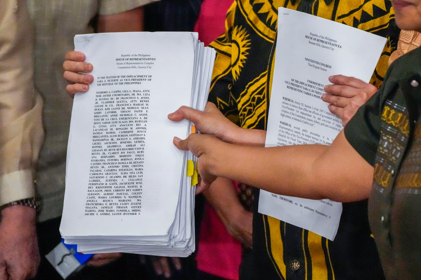 Activists hold a copy of a second impeachment complaint filed against Philippine Vice President Sara Duterte on Wednesday Dec. 4, 2024 at the House of Representatives in Quezon City, Philippines. (AP Photo/Aaron Favila)