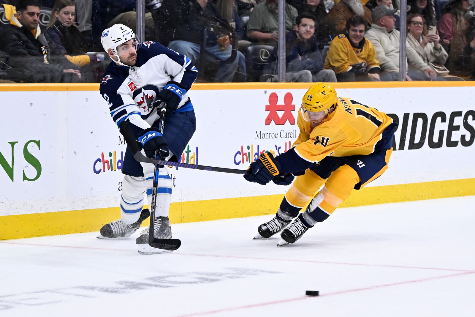 Winnipeg Jets defenseman Dylan DeMelo (2) gets a pass off as Nashville Predators center Gustav Nyquist (14) defends during the second period of an NHL hockey game Thursday, Feb. 27, 2025, in Nashville, Tenn. (AP Photo/John Amis)