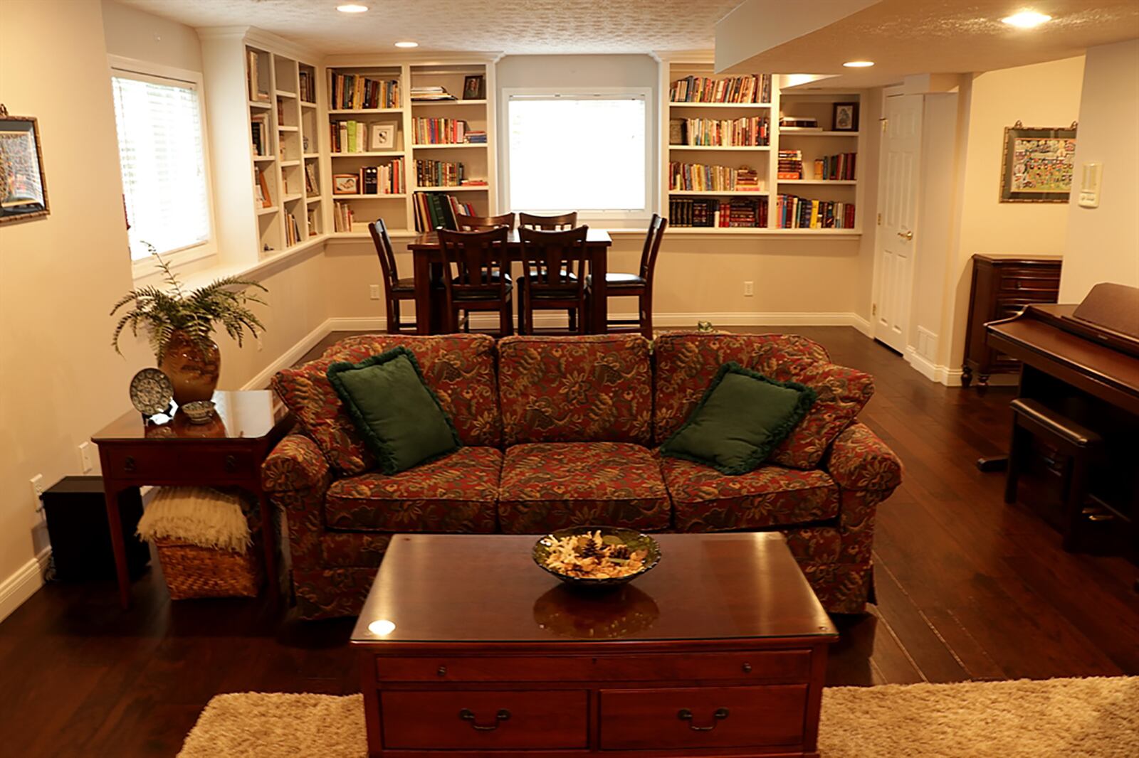 A staircase ends within a combination recreation room and media room in the lower level. Two large daylight windows are surrounded by built-in bookcases. Textured wood flooring fills the room. A possible fifth bedroom and half bathroom complete the finished lower level. CONTRIBUTED PHOTO BY KATHY TYLER