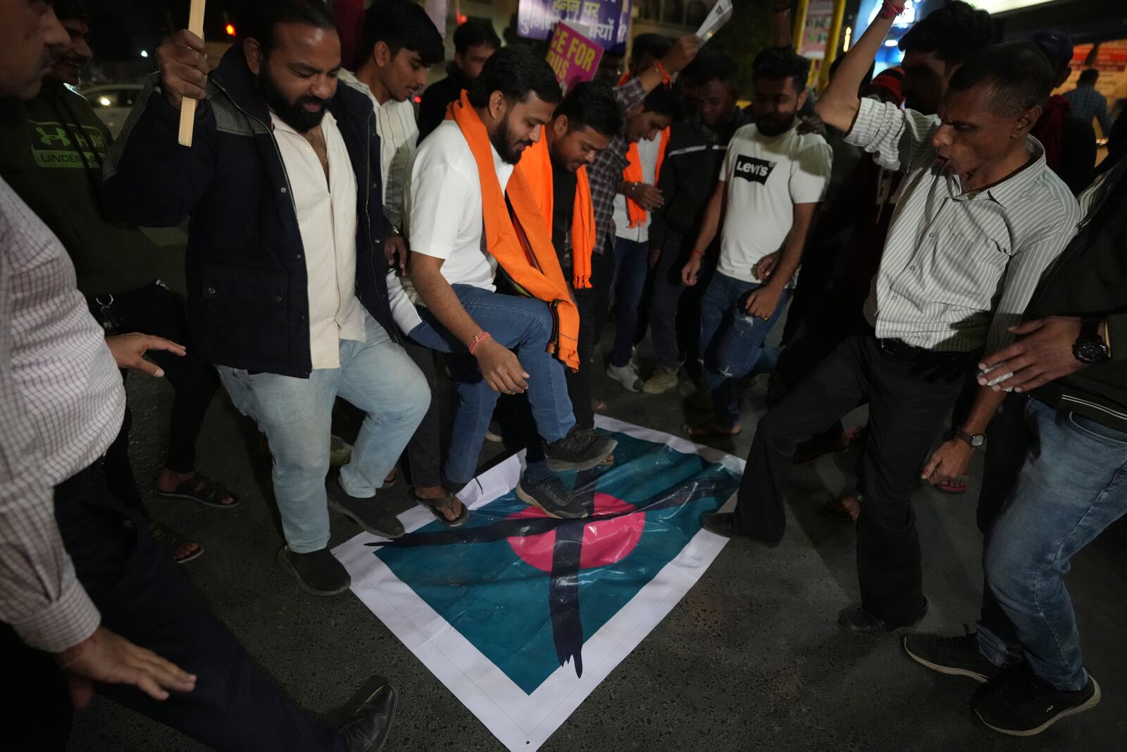 Activists of Bajarang dal, a Hindu rights group, step on a symbolic flag of Bangladesh, during a protest against the alleged attacks on Hindus in Bangladesh, in Ahmedabad, India, Wednesday, Dec. 11, 2024. (AP Photo/Ajit Solanki)