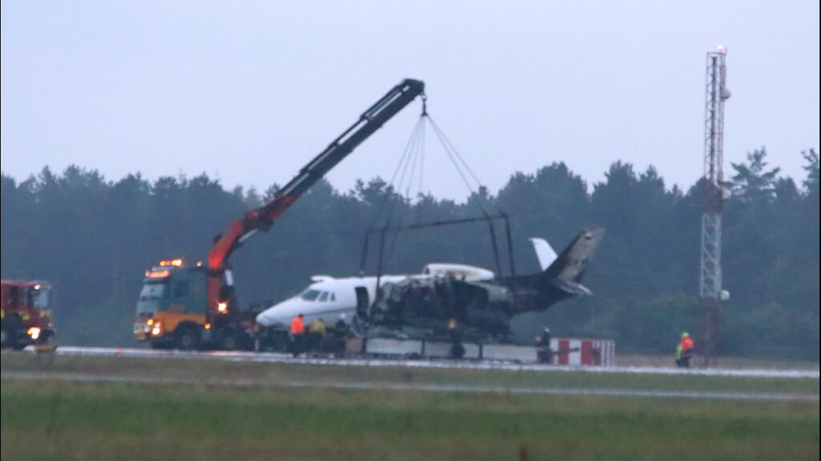 A private aircraft is recovered after it caught fire on landing at Aarhus Airport in Tirstrup, Denmark, Tuesday, Aug. 6, 2019. The plane was believed to be carrying the manager and crew of pop singer Pink.