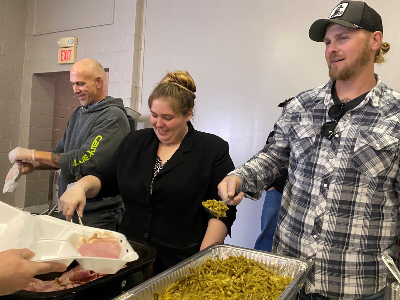 Nick Miller, far right, serves a patron at Evangel Church of God in East Dayton on Nov. 24, 2022. Also pictured, right to left: Samantha Ortega and Mark Oney. Eileen McClory / STAFF