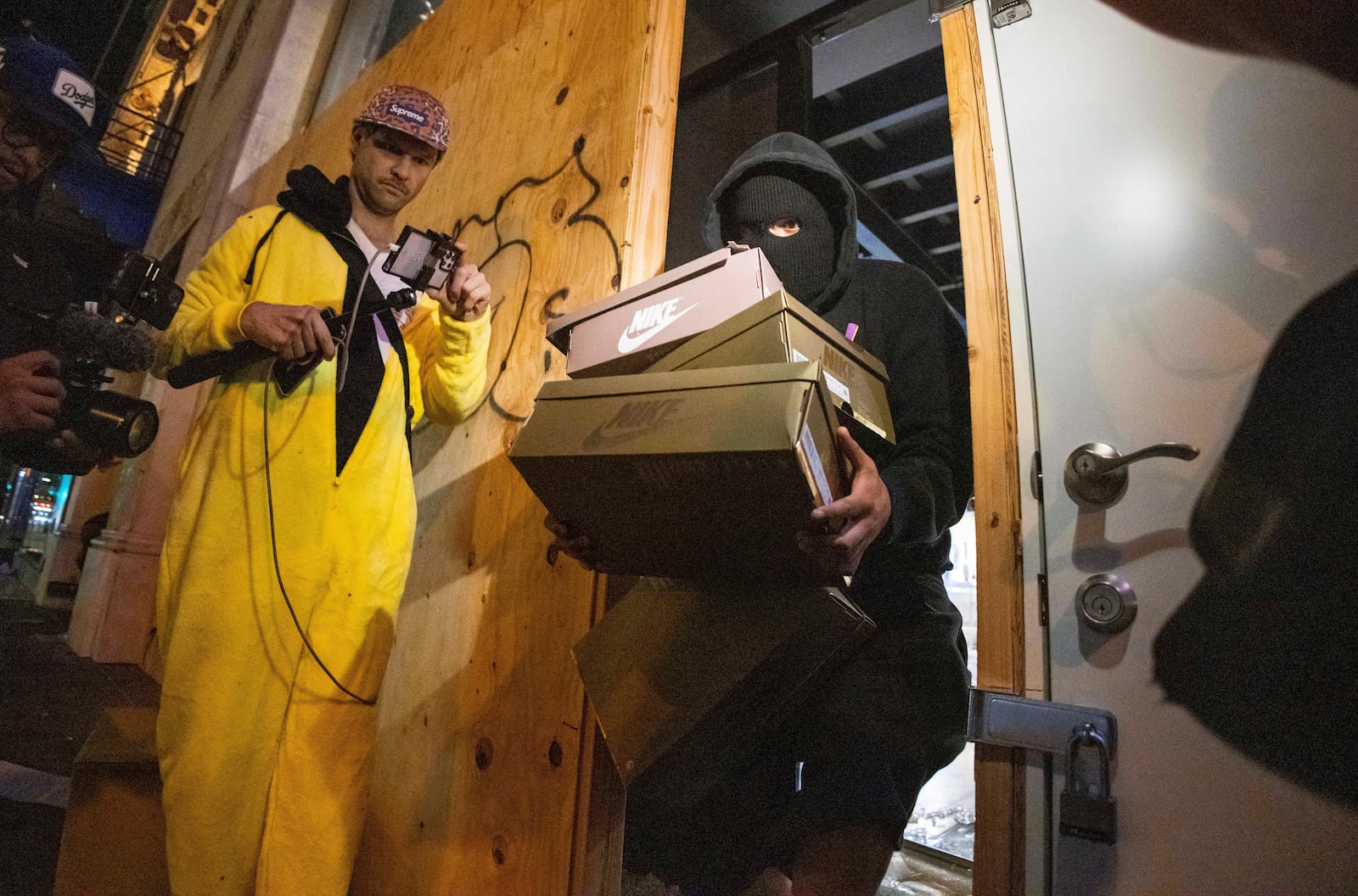 A person carries out items from a ransacked Nike store after the Los Angeles Dodgers defeated the New York Yankees to win the baseball World Series Wednesday, Oct. 30, 2024, in Los Angeles. (AP Photo/Ethan Swope)