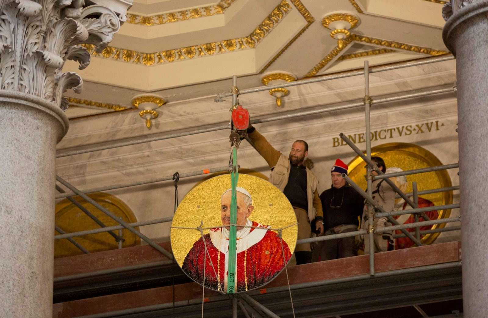 FILE-- A mosaic icon of Pope Francis is lifted to be placed next to the icon of Benedict XVI inside St. Peter and Paul's Basilica in Rome, Monday, Dec. 9, 2013. (AP Photo/Alessandra Tarantino)