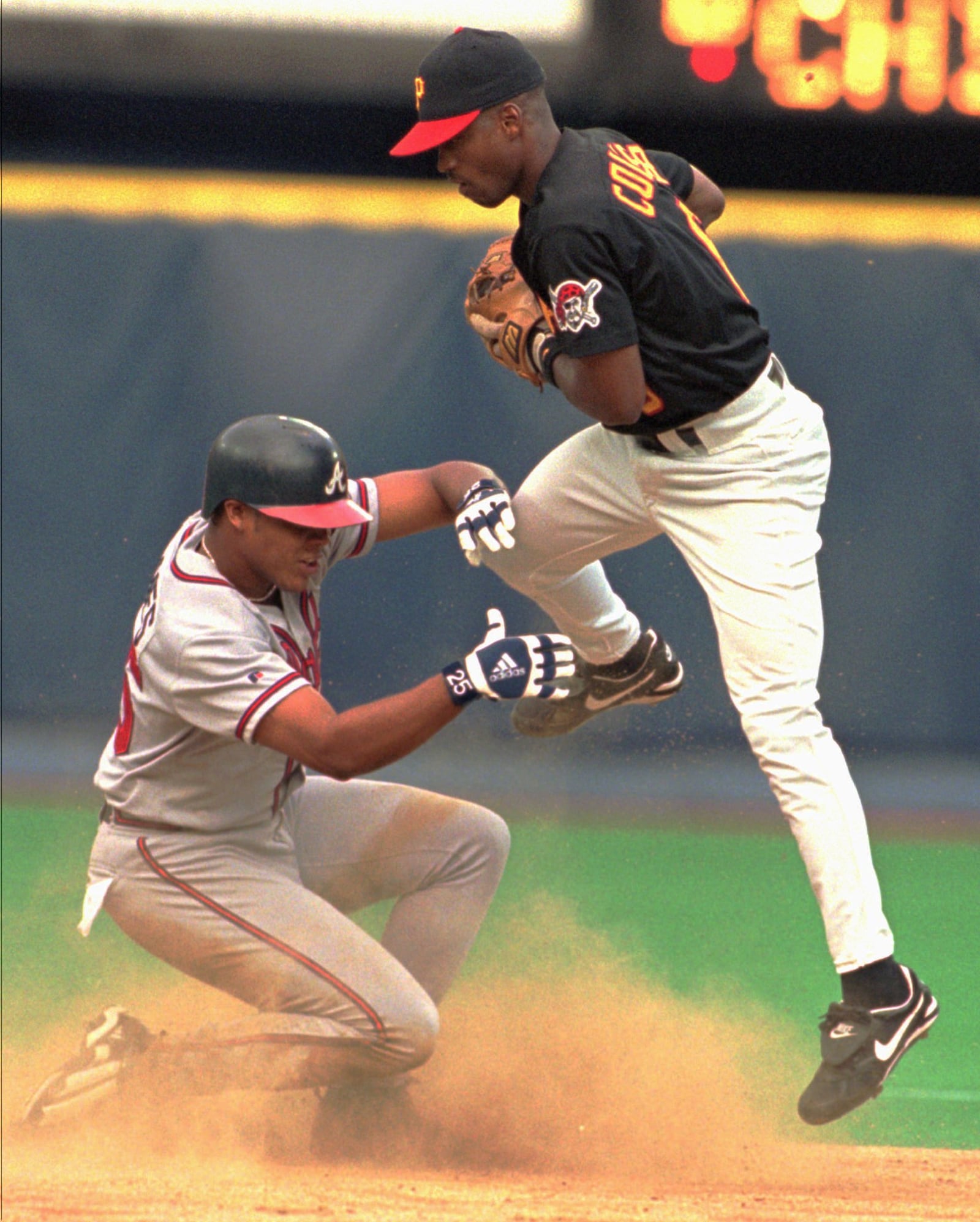 Atlanta Braves' Andruw Jones, left, breaks up a potential double play by sliding into Pittsburgh Pirates shortstop Lou Collier in the second inning Friday, July 24, 1998, in Pittsburgh. Braves' Andres Galarraga was safe at first on the play. (AP Photo/Keith Srakocic)