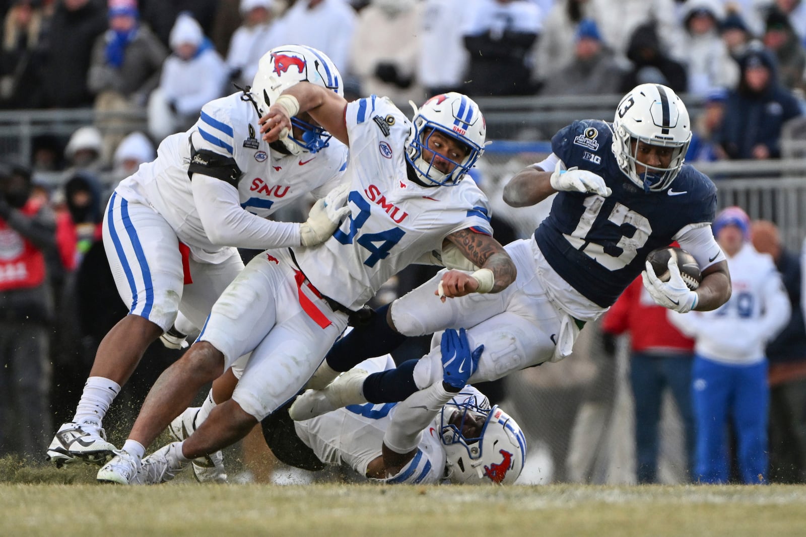 Penn State running back Kaytron Allen (13) is tackled by SMU linebacker Ahmad Walker (34) during the second half in the first round of the College Football Playoff, Saturday, Dec. 21, 2024, in State College, Pa. (AP Photo/Barry Reeger)