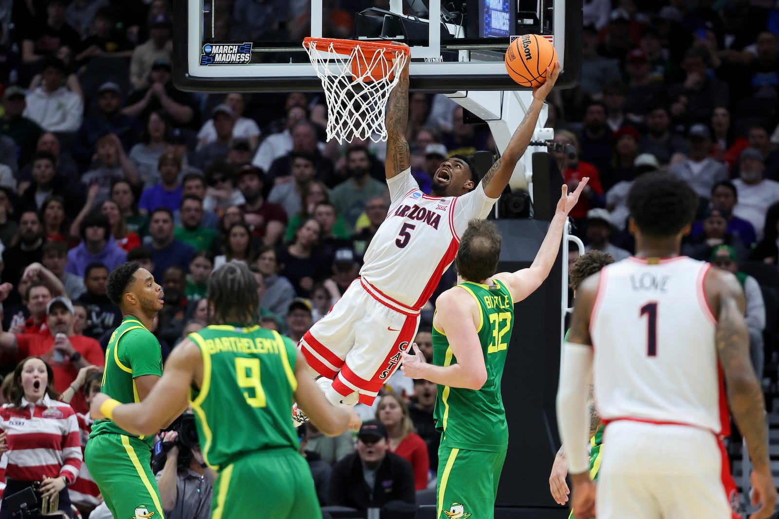 Arizona guard KJ Lewis (5) attempts to shoot against Oregon center Nate Bittle (32) during the second half in the second round of the NCAA college basketball tournament, Sunday, March 23, 2025, in Seattle. (AP Photo/Ryan Sun)