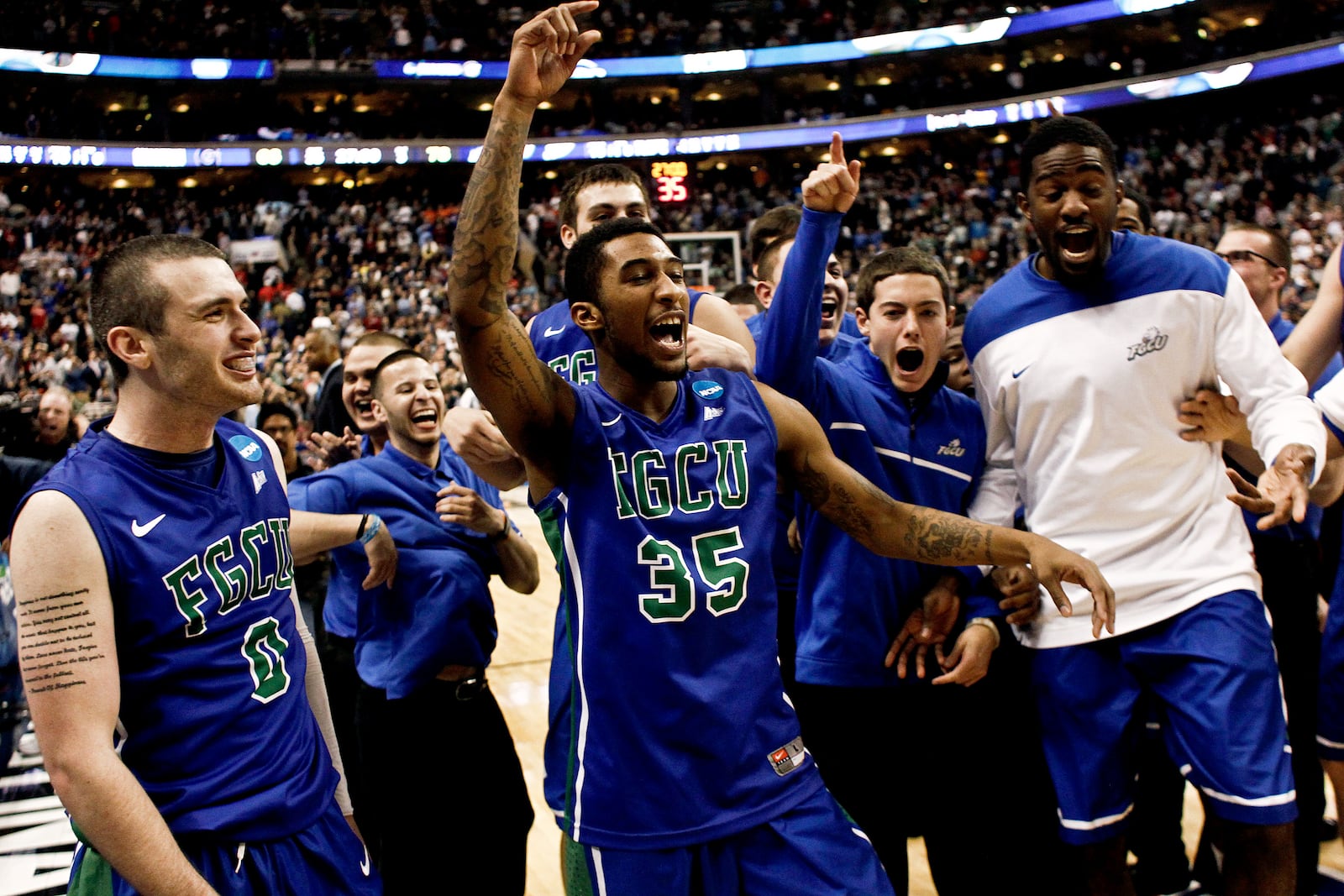 In this Friday, March 22, 2013, photo, Florida Gulf Coast's Brett Comer (0), Dajuan Graf (35) and others celebrate their 78-68 win over Georgetown in a second-round game in the NCAA college basketball tournament in Philadelphia. (AP Photo/Naples Daily News, Scott McIntyre) FORT MYERS OUT