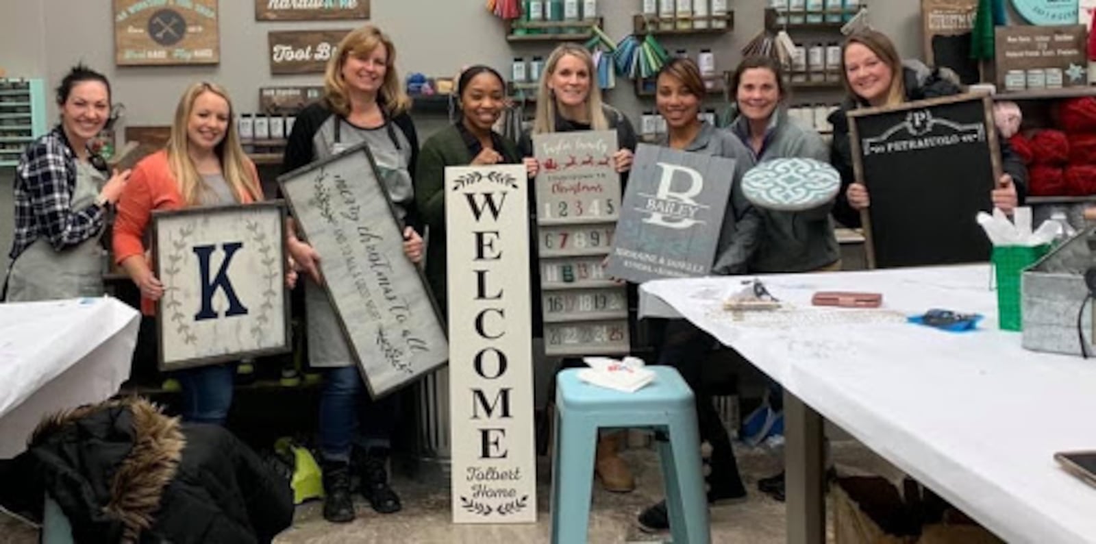 Customers hold up DIY projects that they created at an AR Workshop Centerville event.