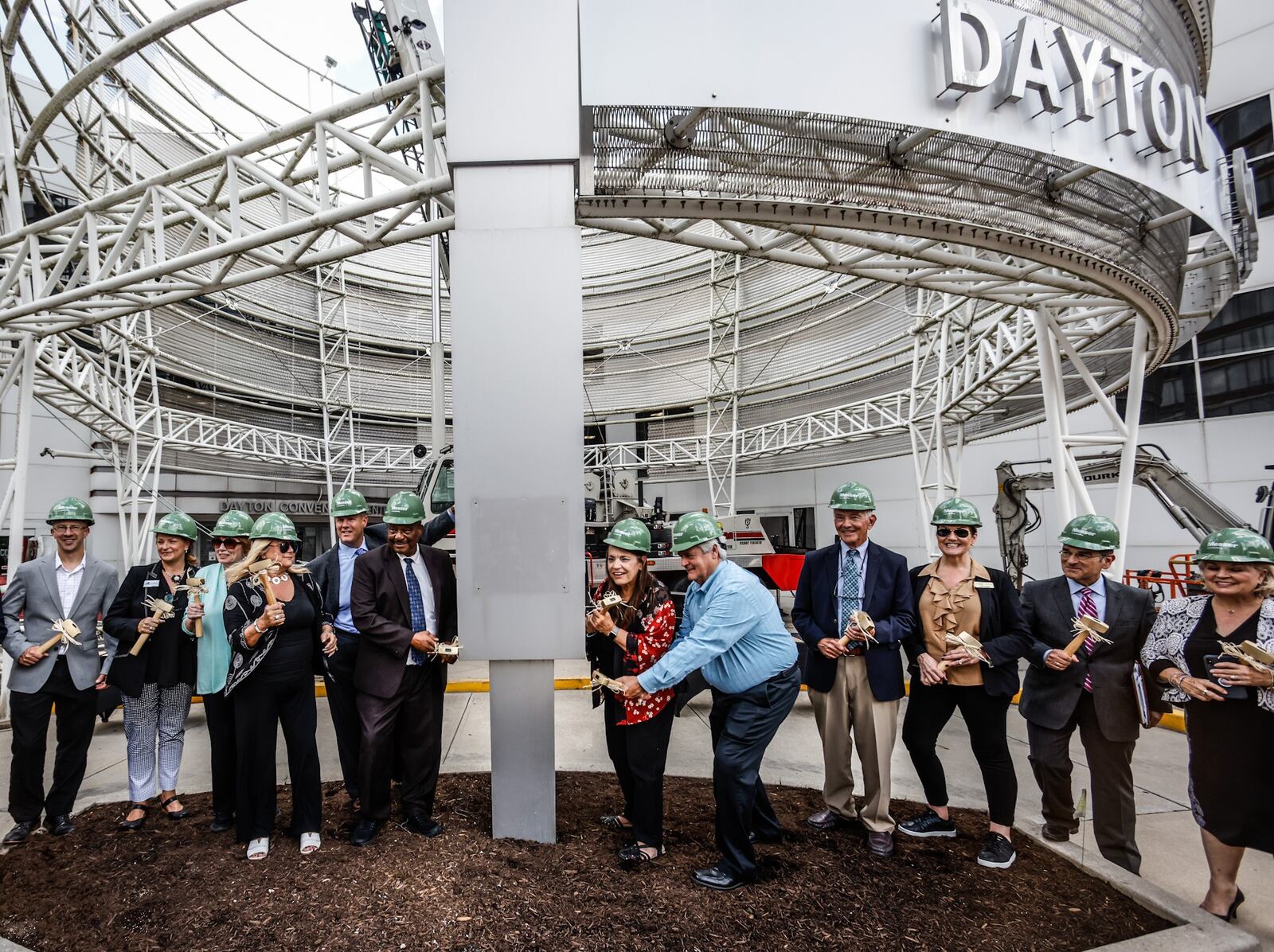 Montgomery County officials "tap out" the old decorative, three-story steel mesh rotunda a the entrance of the Dayton Convention Center. The demolition work helped officially kick off $31 million in major planned improvements to the facility. JIM NOELKER/STAFF