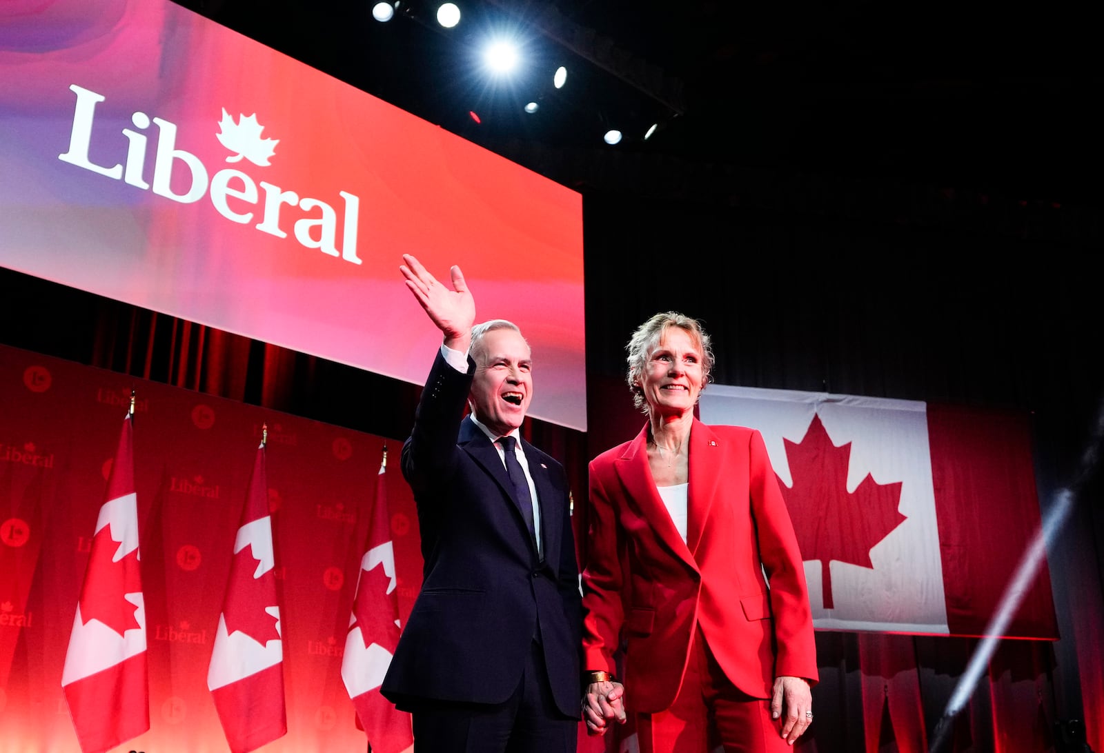 Mark Carney, Leader of the Liberal Party of Canada, waves with his wife Diana Fox Carney after his speech after being announced the winner at the Liberal Leadership Event in Ottawa, Ontario, Sunday, March 9, 2025. (Justin Tang/The Canadian Press via AP)