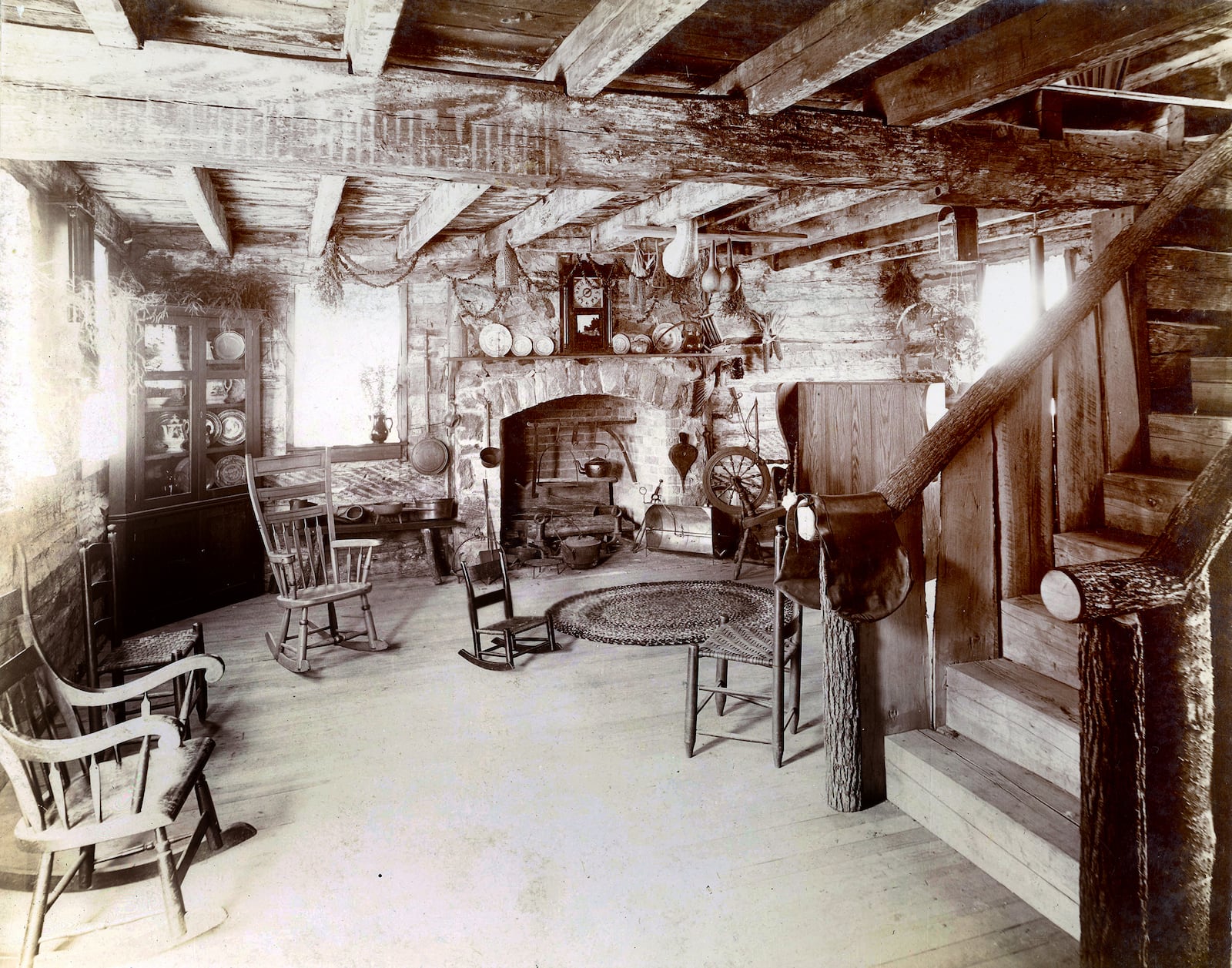 An interior view of the west end of the living room shows the corner cupboard, fireplace, and part of the stairway in Newcom Tavern. This photograph was taken by Ralph Bowersox when the structure was open to the public for the Dayton Centennial in 1896. DAYTON METRO LIBRARY