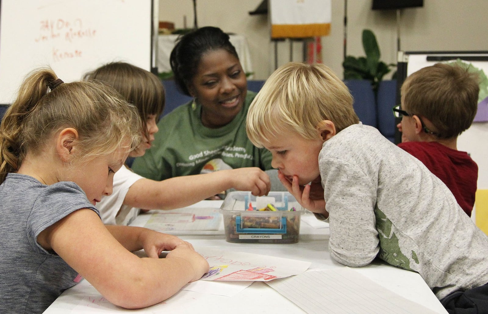 Good Shepherd Academy center manager Eartha DeWalt works with students in a classroom within the Jubilee Community Church in Springboro. TY GREENLEES / STAFF