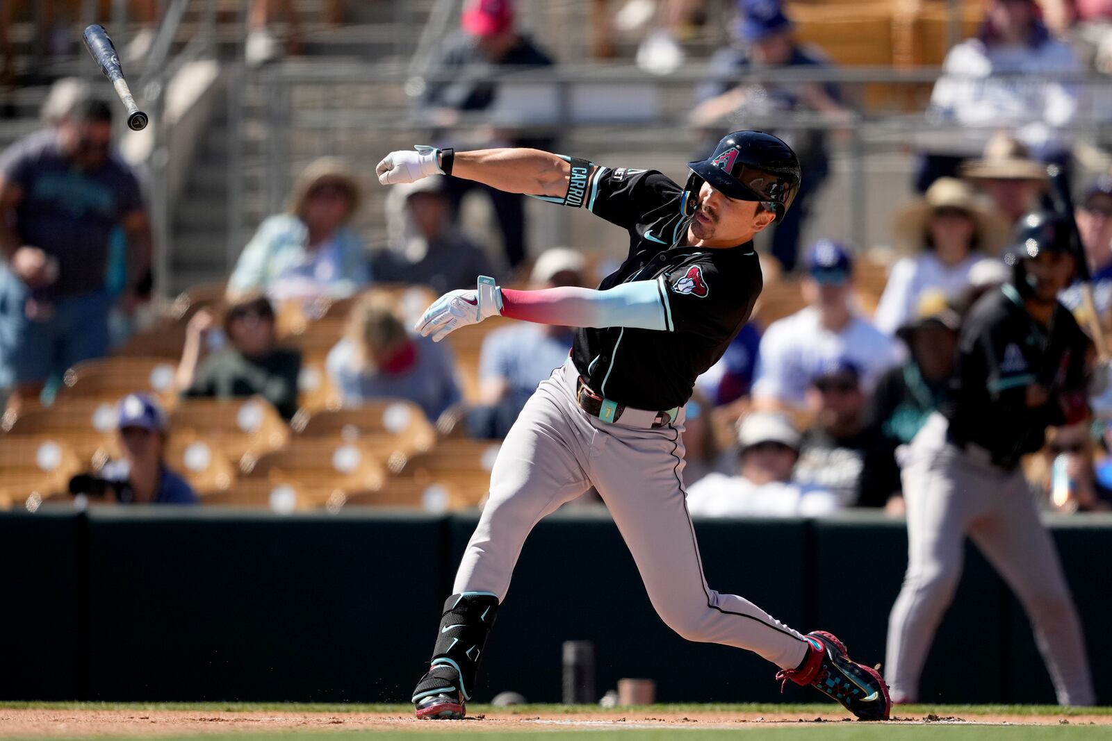 Arizona Diamondbacks' Corbin Carroll loses his bat on a swing during the first inning of a spring training baseball game against the Los Angeles Dodgers, Monday, March 10, 2025, in Phoenix. (AP Photo/Matt York)