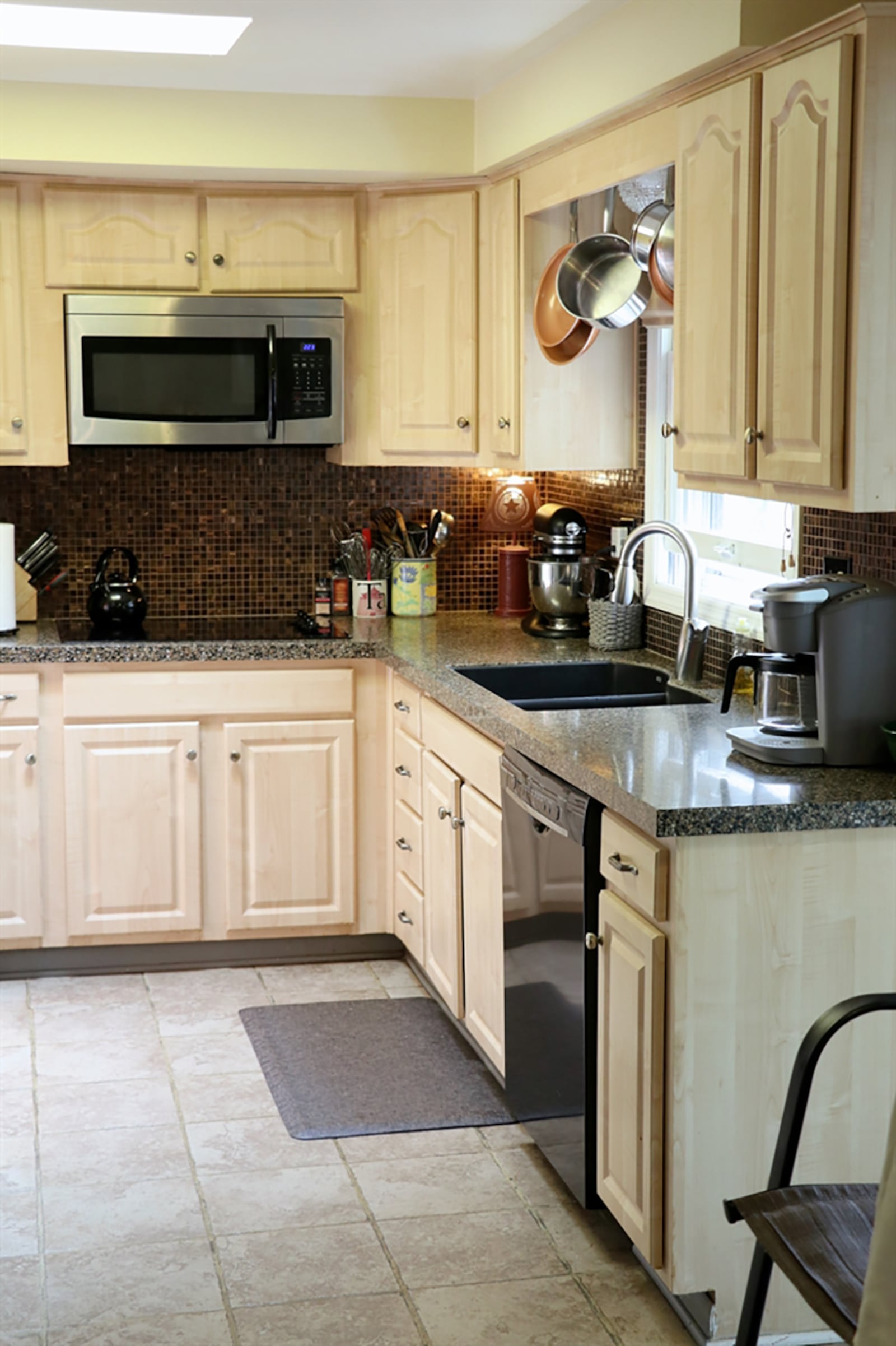 Off the dining room is the galley kitchen which has been updated with granite countertops and light cabinetry. A double sink is below a window, and stainless-steel appliances include double wall ovens, a glass cooktop, microwave and dishwasher. CONTRIBUTED PHOTO BY KATHY TYLER