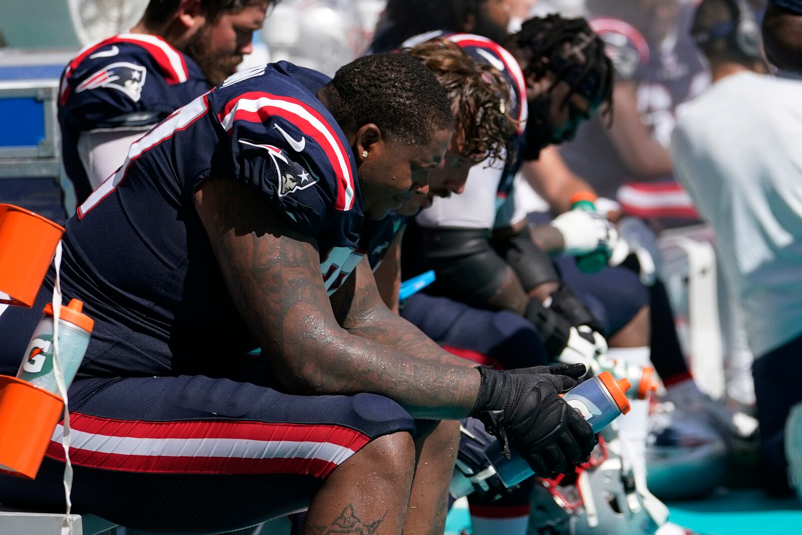 New England Patriots offensive tackle Trent Brown (77) and his teammates sit on the sidelines during the second half of an NFL football game against the Miami Dolphins, Sunday, Sept. 11, 2022, in Miami Gardens, Fla. The Dolphins defeated the Patriots 20-7. (AP Photo/Lynne Sladky)