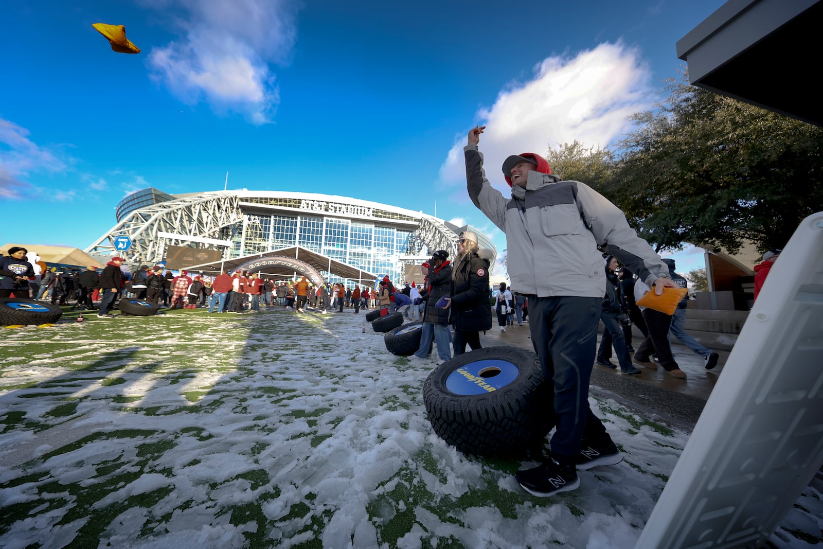 FILE - Tailgaters participate in a game of cornhole outside AT&T Stadium prior to the Cotton Bowl College Football Playoff semifinal game between Ohio State and Texas, Friday, Jan. 10, 2025, in Arlington, Texas. (AP Photo/Gareth Patterson, File)