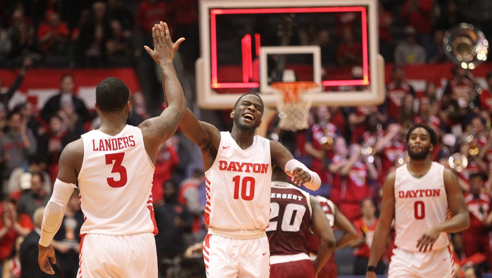 Dayton’s Jalen Crutcher, center, slaps hands with Trey Landers after a victory against Massachusetts on Sunday, Jan. 13, 2019, at UD Arena. David Jablonski/Staff