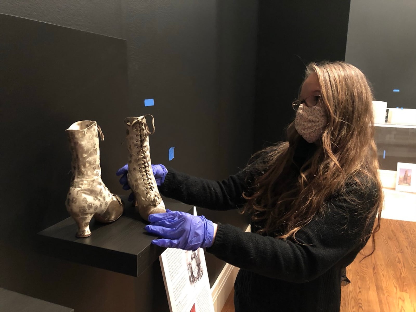 Curator Ann Glasscock installs shoes for “Walk This Way,” the current exhibit at the Taft Museum of Art. CONTRIBUTED