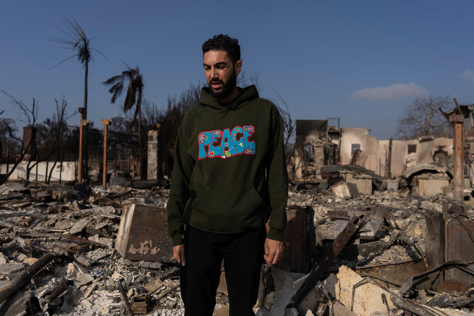 World Central Kitchen Chef Corp member Daniel Shemtob pauses as he walks through what remains of his home destroyed by the Palisades Fire, Sunday, Jan. 19, 2025, in the Pacific Palisades neighborhood of Los Angeles, Calif. (AP Photo/Carolyn Kaster)