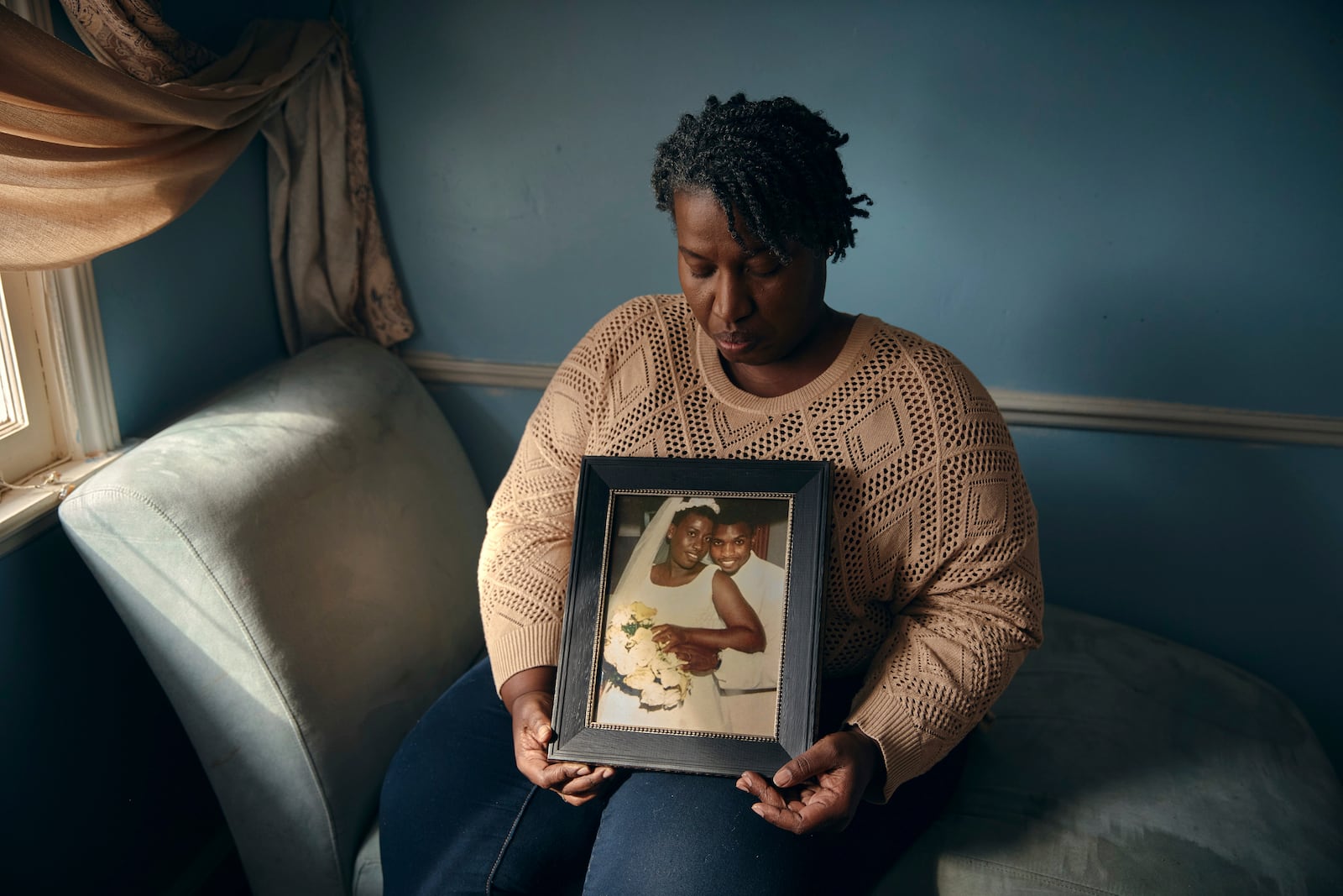 Sharline Volcy holds a photo from her wedding to Ronald Donat, on Monday, Feb. 3, 2025, in Orange, N.J. (AP Photo/Andres Kudacki)