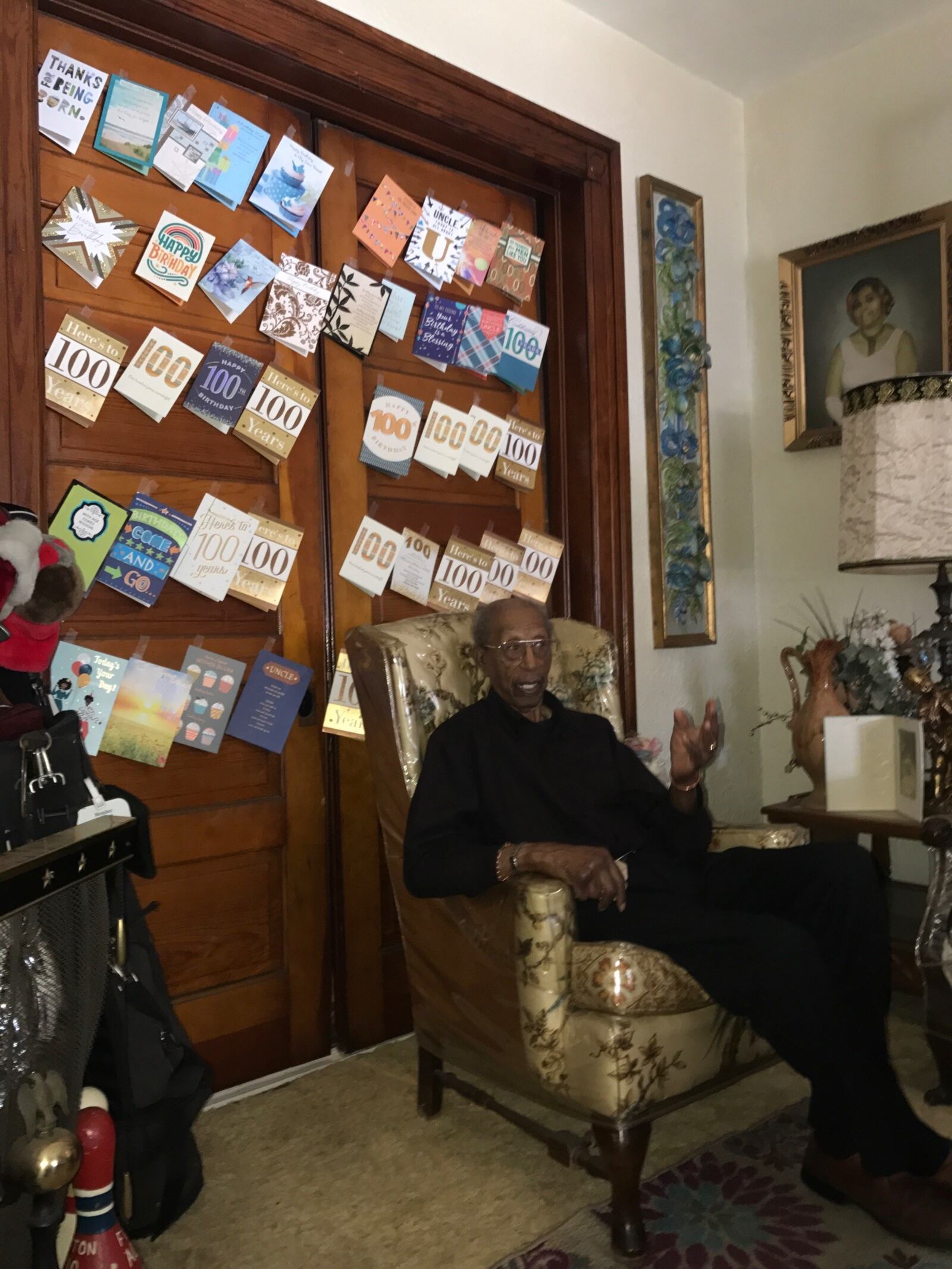 Marion Martin sits in his living room of his West Dayton home Wednesday on his 100th birthday. Some of the cards he received are on the wall behind him. His golf bag and clubs sit in a corner of the room. Tom Archdeacon/CONTRIBUTED