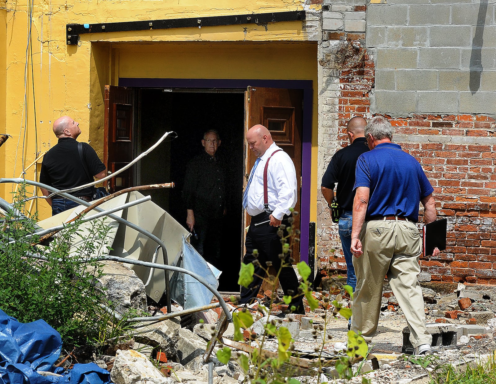 Structural engineer Daniel Geers, of Jezerinac Geers & Associates Inc. (left) examines the 1800s-era Tavern building at 112-118 West Main Street in Troy on Friday, Aug. 18, 2023. Also present were Aaron Lowe (white shirt) of law firm Waite, Tomb, Eberly; Wade Dexter of the Troy Fire Department and assistant Miami County prosecuting attorney Chris Englert (at right); and J. Steven Justice of Dungan & LeFevre law firm (inside building). MARSHALL GORBY\STAFF