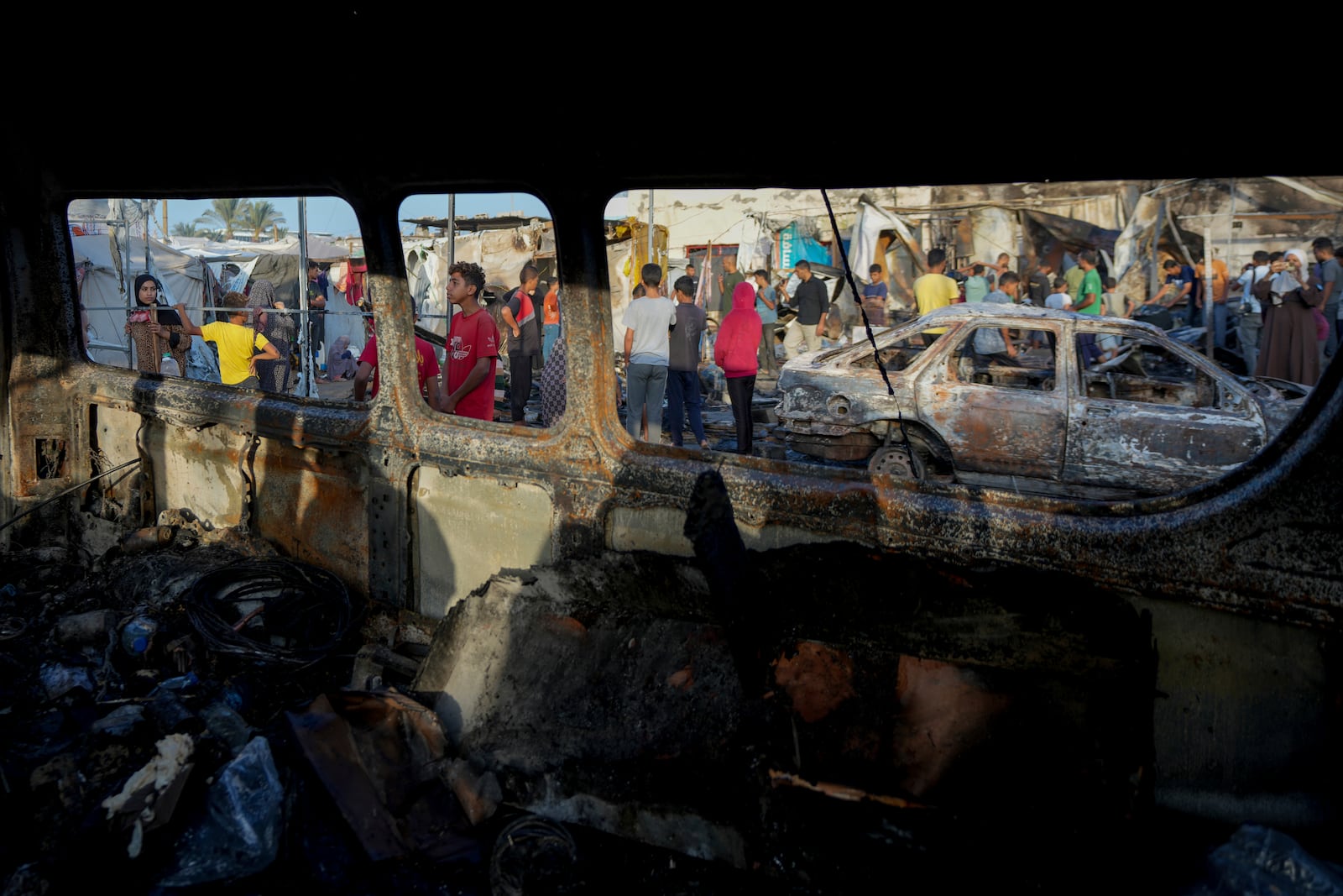 Palestinians look at the damage after an Israeli strike hit a tent area in the courtyard of Al Aqsa Martyrs hospital in Deir al Balah, Gaza Strip, Monday, Oct. 14, 2024. (AP Photo/Abdel Kareem Hana)