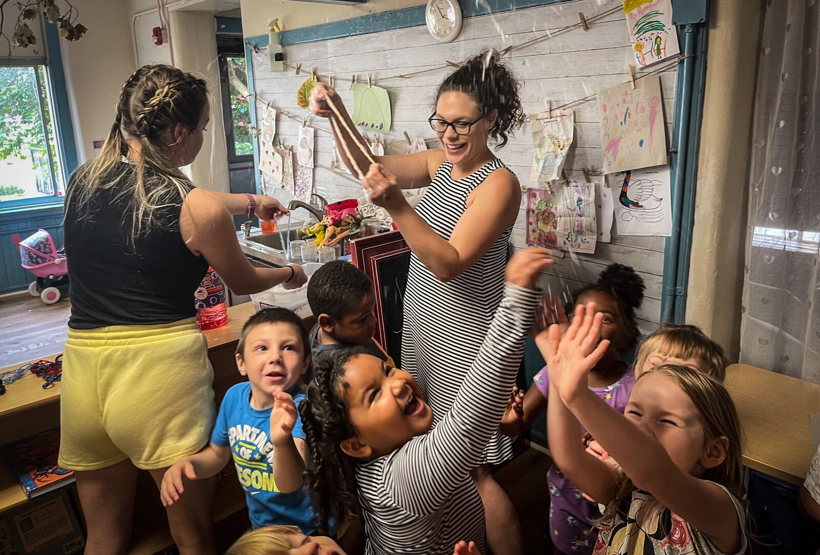 Rainbow Years Child Care Center teachers from left, Abbie Beirise and Heather Simonds use bubbles to get the children to use their whole bodies before lunch Friday June 4, 2021. The senate budet proposal would eliminate funding for a child-care quality program. JIM NOELKER/STAFF