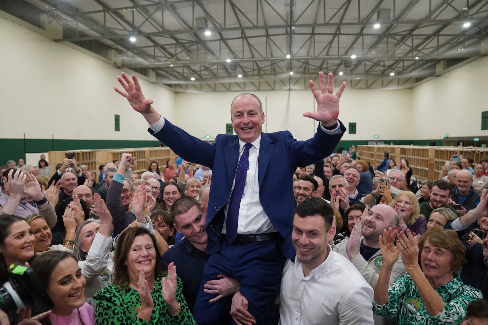 Fianna Fail leader Micheal Martin is hoisted up by his sons Cillian and Micheal Aodh, after he was deemed elected in the Cork South Central constituency at the election count centre at Nemo Rangers GAA Club in Cork, after the General Election, Saturday Nov. 30, 2024. (Jacob King/PA via AP)