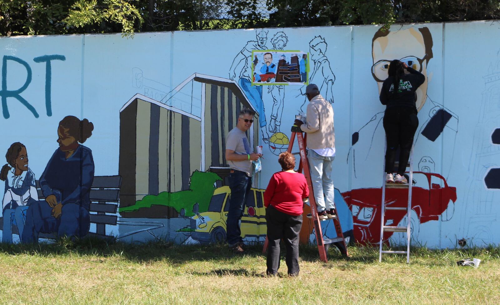 Jason Antonick, Rebecca Gaytko, Shirley Tucker and Morris Howard work on the new Steve Whalen memorial mural on Friday. The original mural was defaced last year. Whalen, a Dayton police officer, was killed while in the line of duty in 1991. CORNELIUS FROLIK / STAFF 