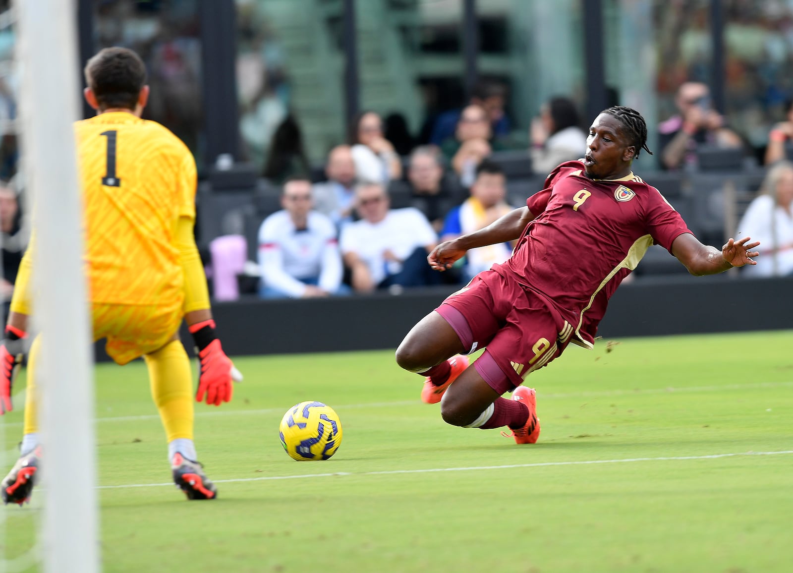 Venezuela forward Jan Hurtado (9) slides for the ball in front of United States goalkeeper Patrick Schulte (1) during the first half of an international friendly soccer game, Saturday, Jan 18, 2025, in Fort Lauderdale, Fla. (AP Photo/Michael Laughlin)